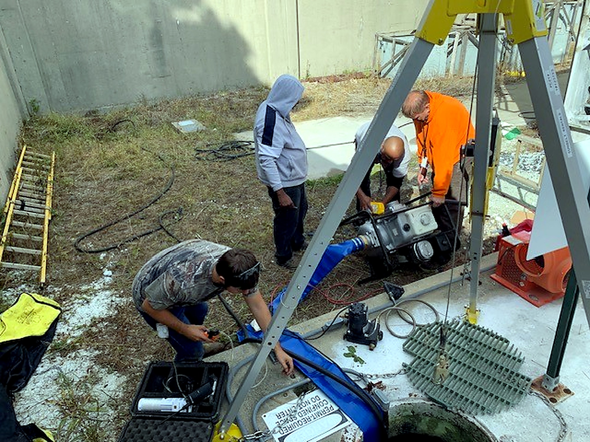 Maintenance crew servicing below-grade facility equipment at Wright-Patterson Air Force Base