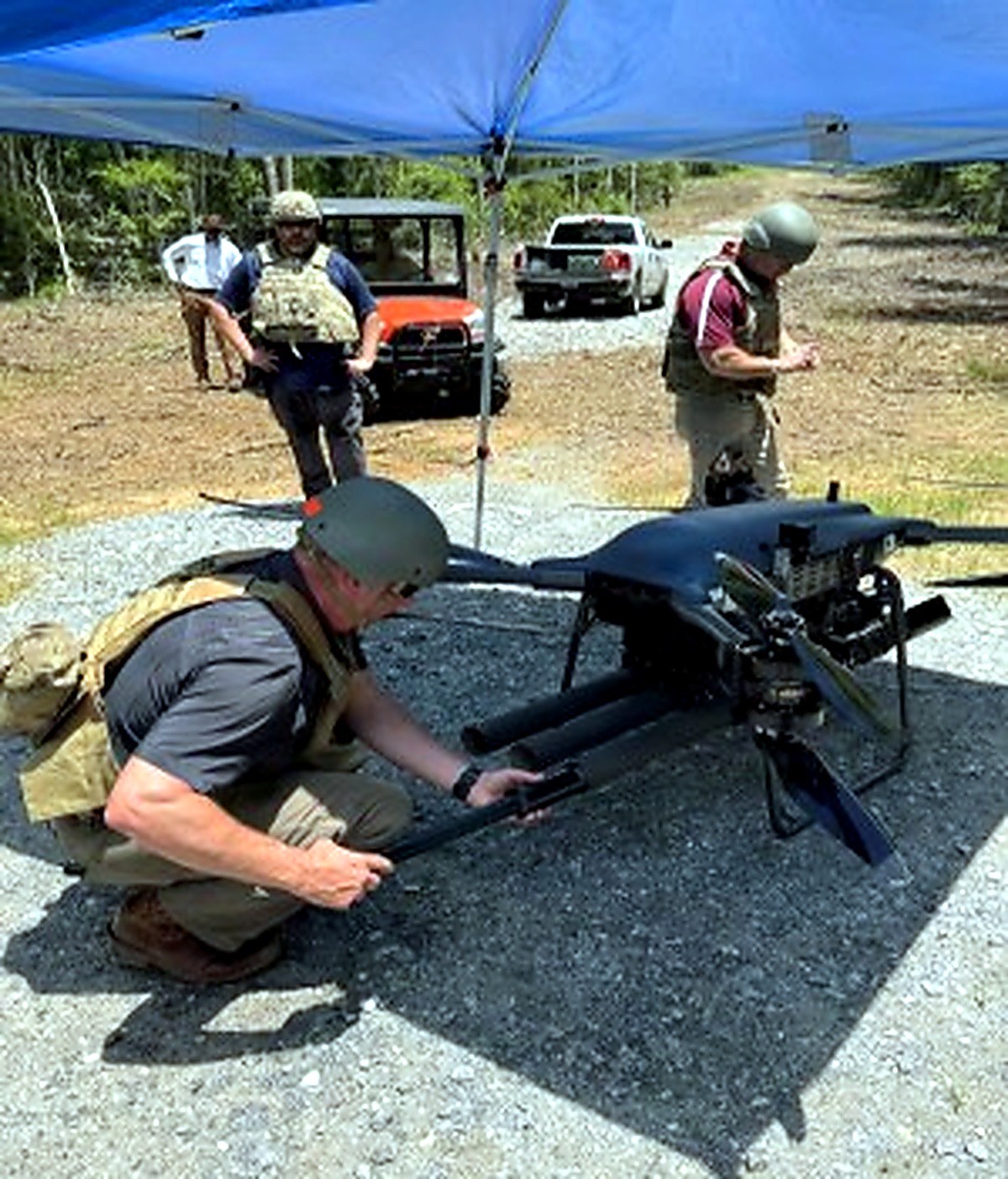 Test personnel preparing a TRV-50 drone and 70 millimeter system at a range