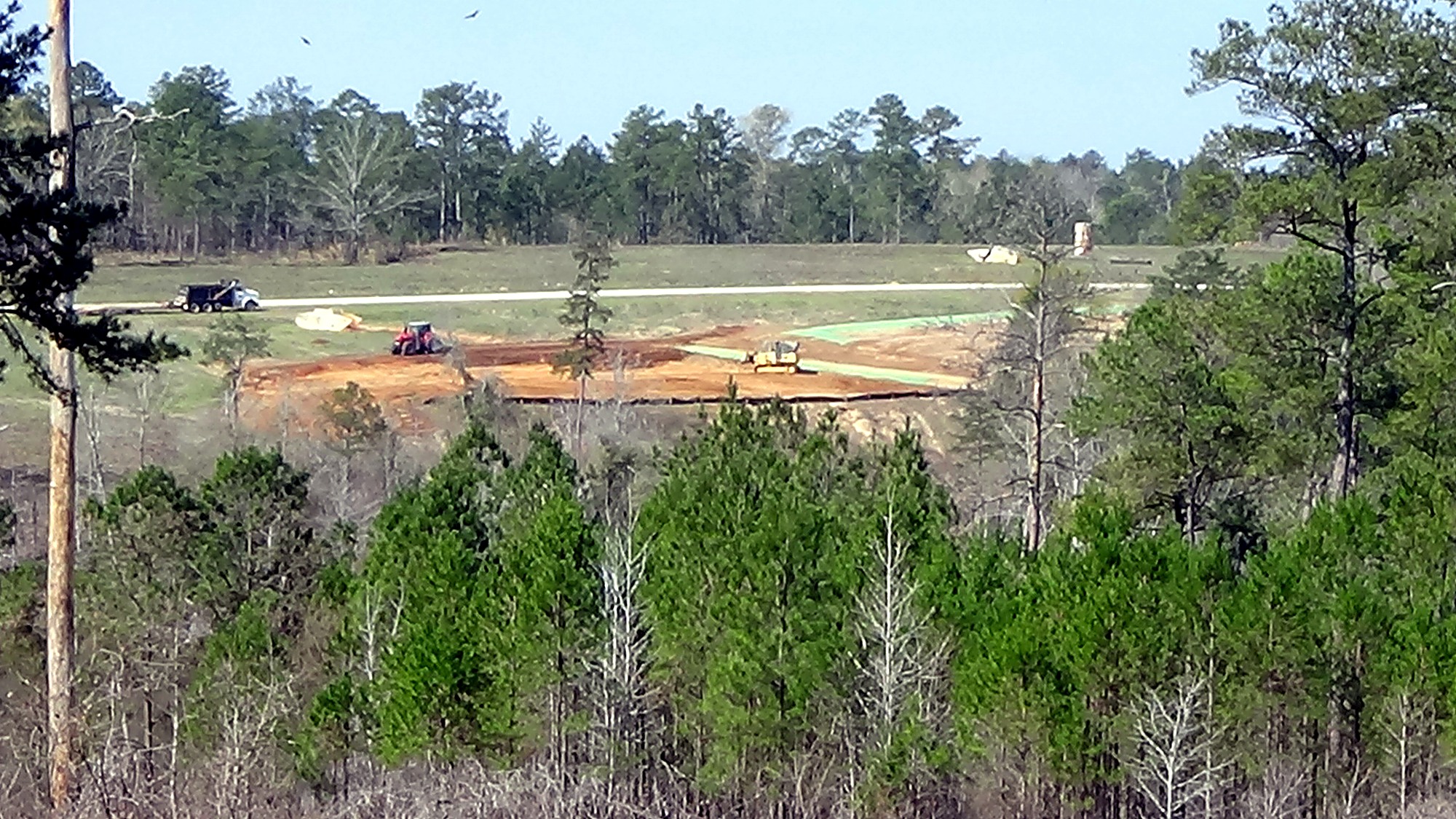 Heavy equipment completing erosion repair work in a wooded training area