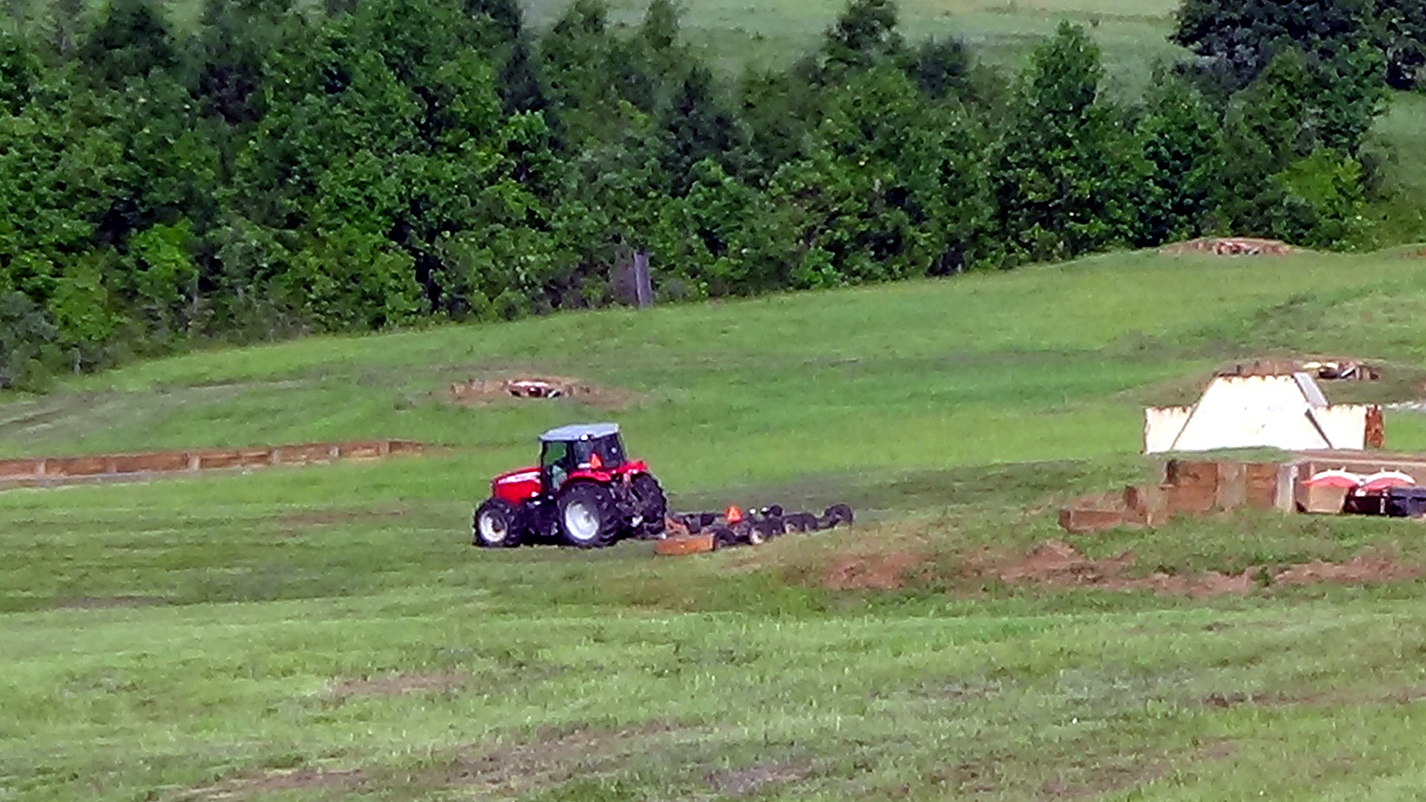 Tractor mowing a grassy military training range