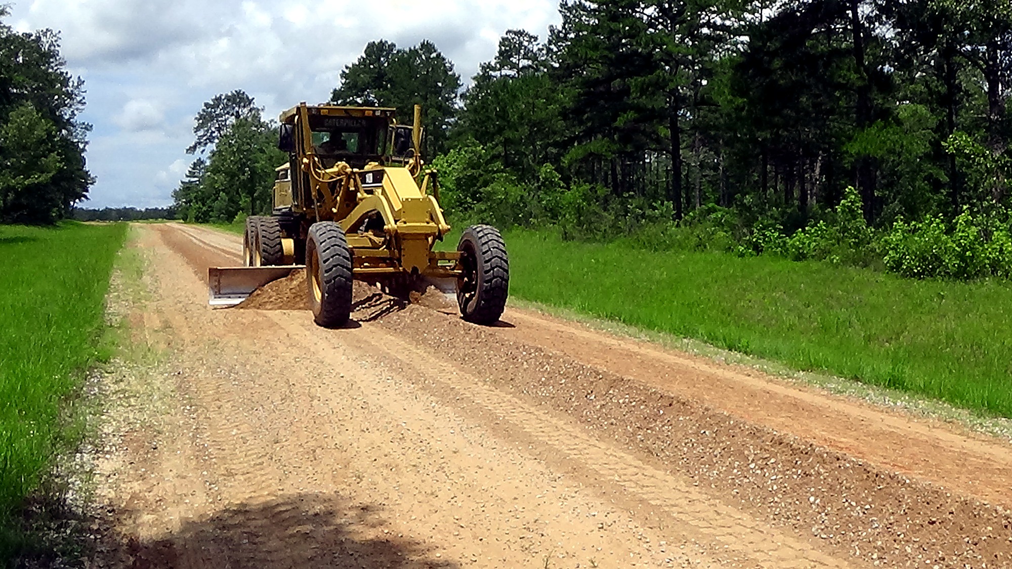 Motor grader maintaining an unpaved installation road